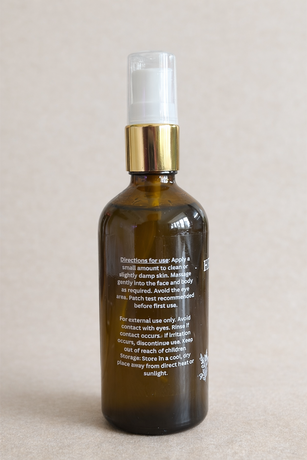 Brown glass bottle with gold cap on a beige background